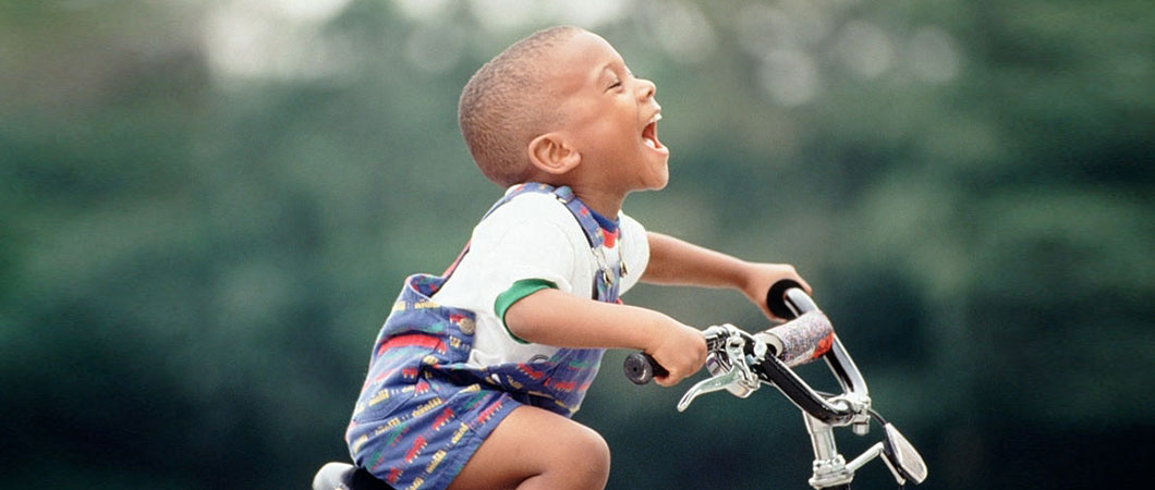 a happy kid enjoying a bike that was donated to him