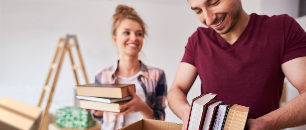 couple packing several books to donate