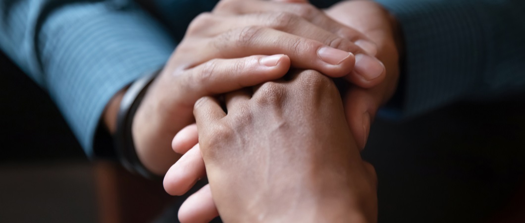 two hands holding each other demonstrating support