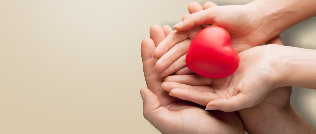 child and adult holding a heart