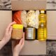 putting canned goods and other foods in a box