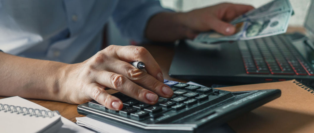 charity owner holding dollar bills and calculator