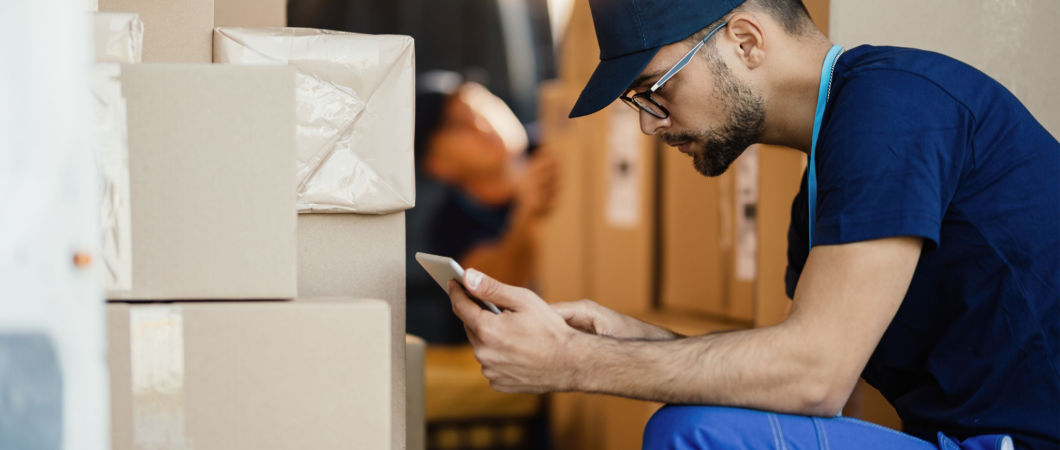 male mover working on touchpad while organizing the boxes