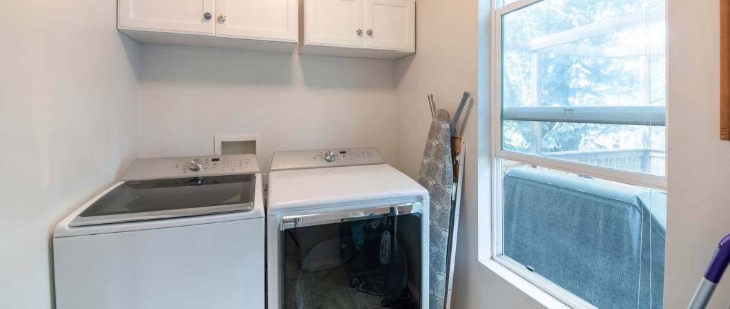 small laundry room with shelf washer dryer and iron board