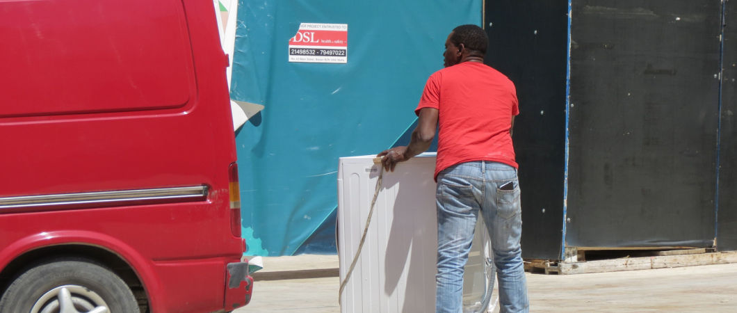 volunteer picking up donated laundry machine