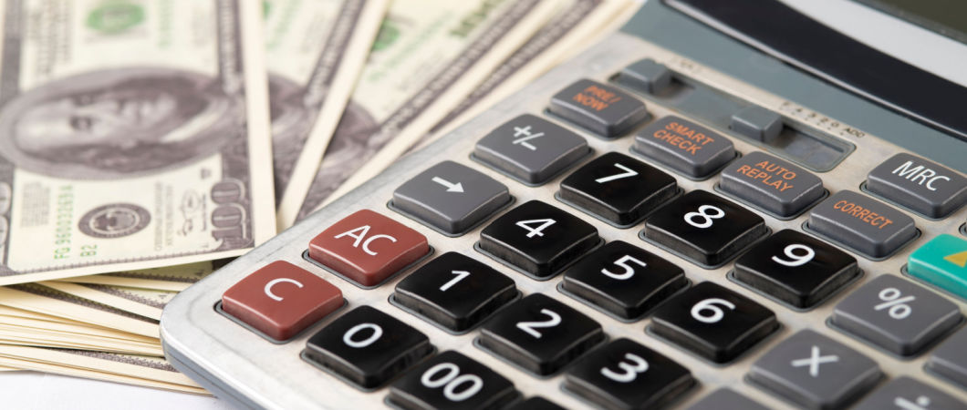 one hundred dollar bills and a calculator