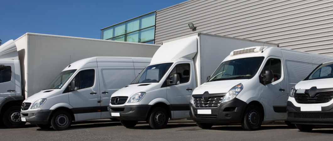white delivery or moving trucks parking at a building