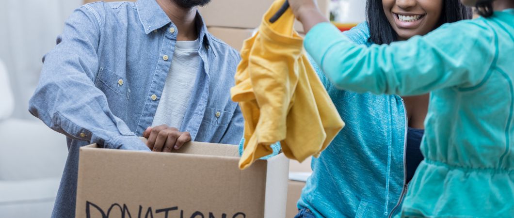 family packs clothes in donation box together