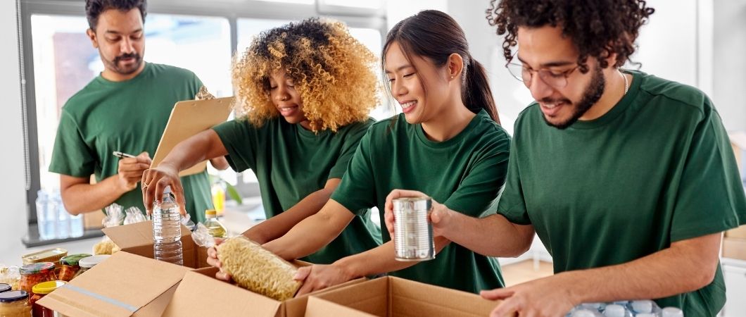 happy volunteers packing food in donation boxes