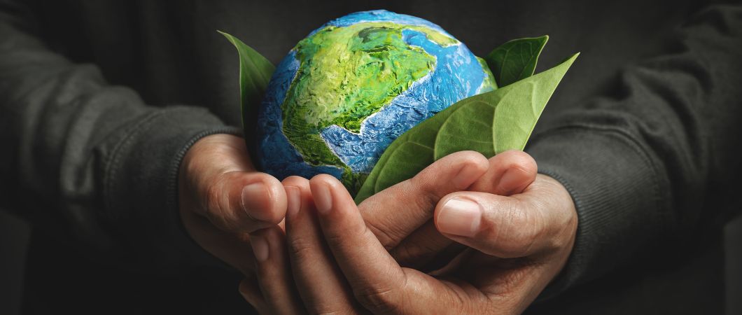 man holding globe and leaves