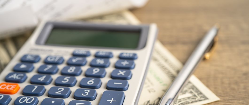 receipt calculator pen and dollar banknotes