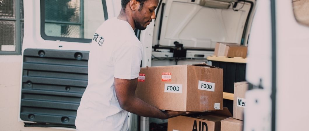 volunteer picks up donated food and first aid kits