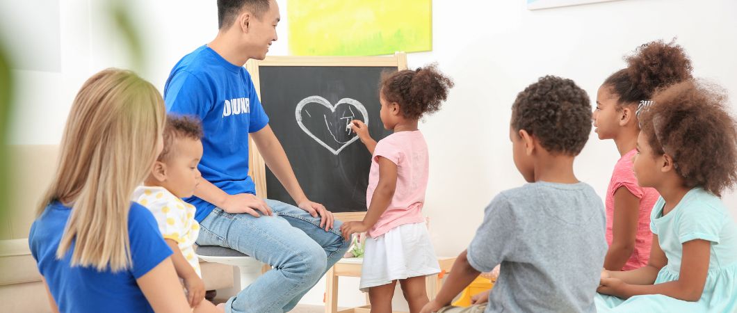 volunteers teaching little children