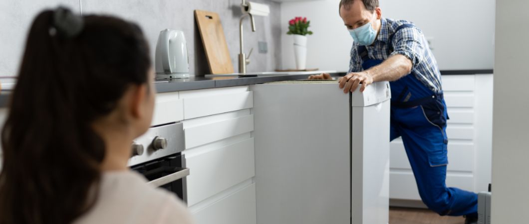 volunteer picking up the donated kitchen dishwasher appliance