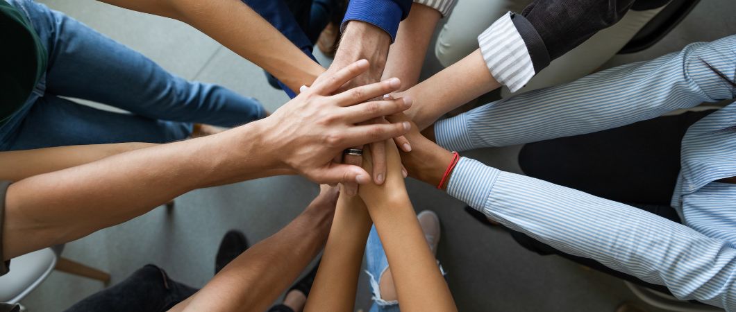 diverse employee staking hands engaged in team building