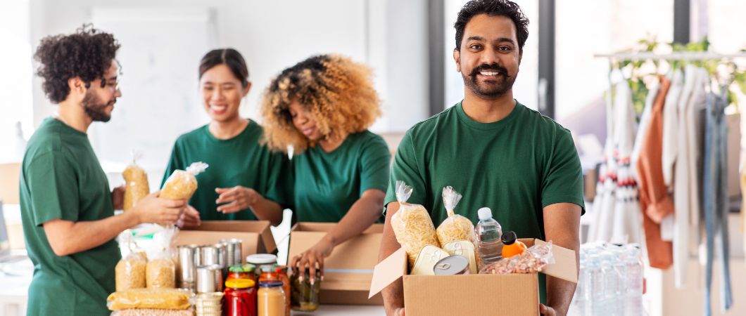 happy volunteers packing food in donation box