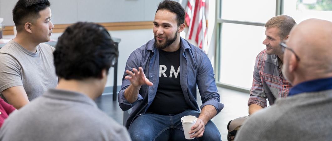mid adult veteran talks with fellow veterans