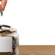 hand putting coins in glass jar