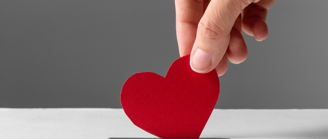 putting red heart in a donation box