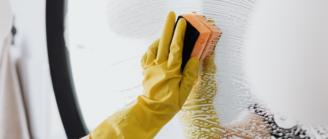 cleaning a mirror with sponge